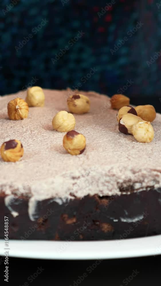 Hands adding nuts on biscuit cake, decorating cake at kitchen. Vertical video Hands adding nuts on biscuit cake, decorating cake at kitchen. Vertical video