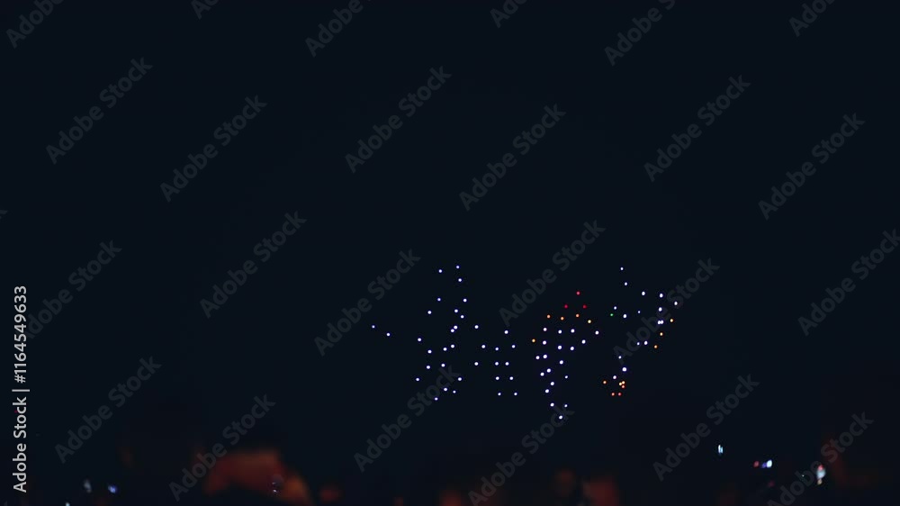 illuminated aerial drone show at glowing night sky, programmed flying robotics light performance over city, people watching and filming, advanced technology concept