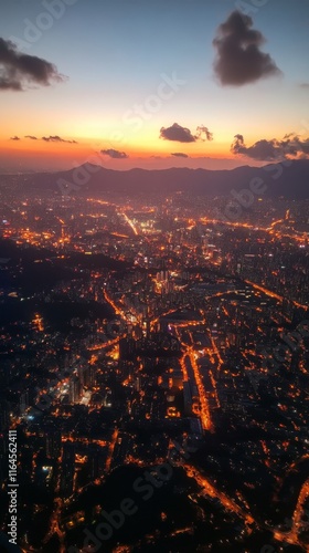 View of city skyline illuminated at sunset with mountains in the background