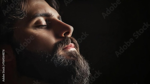 Retrato de hombre con ojos cerrados en fondo negro y con barba arreglada photo