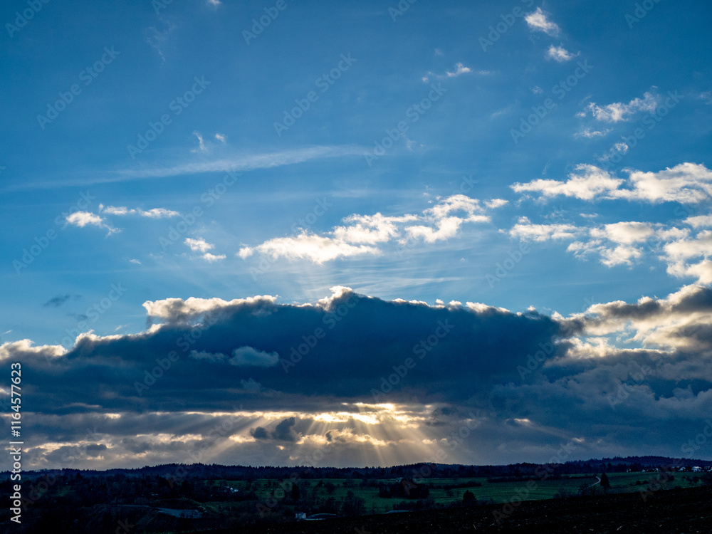Fototapeta premium Lichtstrahlen dringen durch den Wolkenhimmel