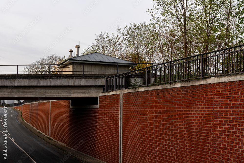Urban landscape featuring a bridge and brick wall in a quiet area Urban landscape featuring a bridge and brick wall in a quiet area