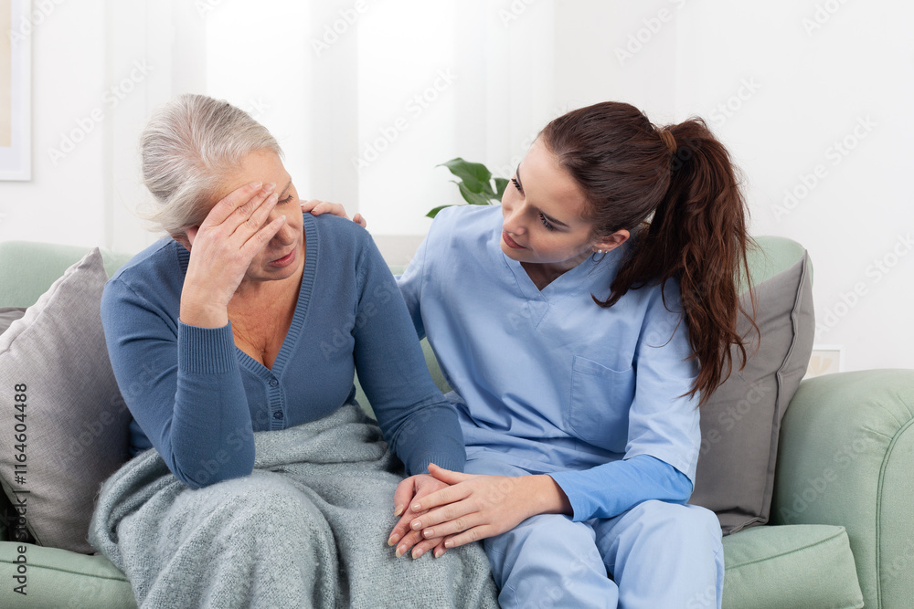 Caring young nurse or doctor comforts an senior woman patient who is upset, stressed, or worried about a problem or pain. Home nursing care or in a medical clinic. Concept of healthcare and insurance Caring young nurse or doctor comforts an senior woman patient who is upset, stressed, or worried about a problem or pain. Home nursing care or in a medical clinic. Concept of healthcare and insurance