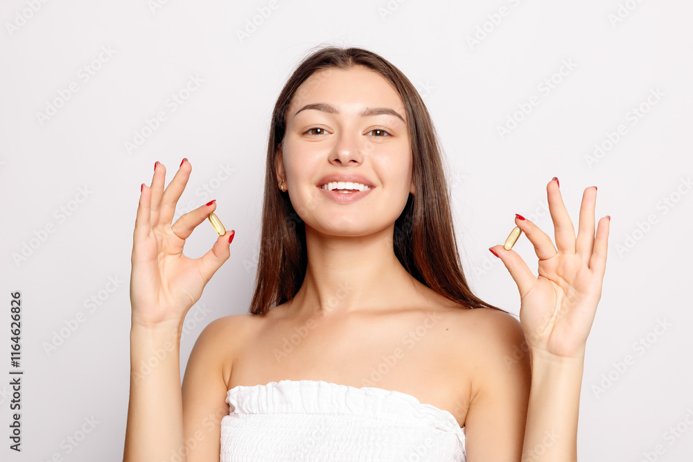 Beautiful Smiling Young Woman Holding Fish Oil Pill In Hand. Beautiful Smiling Young Woman Holding Fish Oil Pill In Hand.