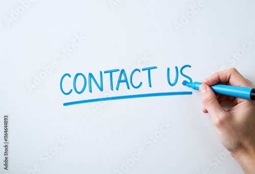 Close-up of a hand writing 'CONTACT US' in bold blue letters on a whiteboard, emphasizing communication and outreach.