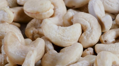 Close-up, slider shot of fresh cashew nuts in a heap. Depth of field, selective focus. Food, nutrition, healthy eating, snacks, ingredient concepts. 4k
