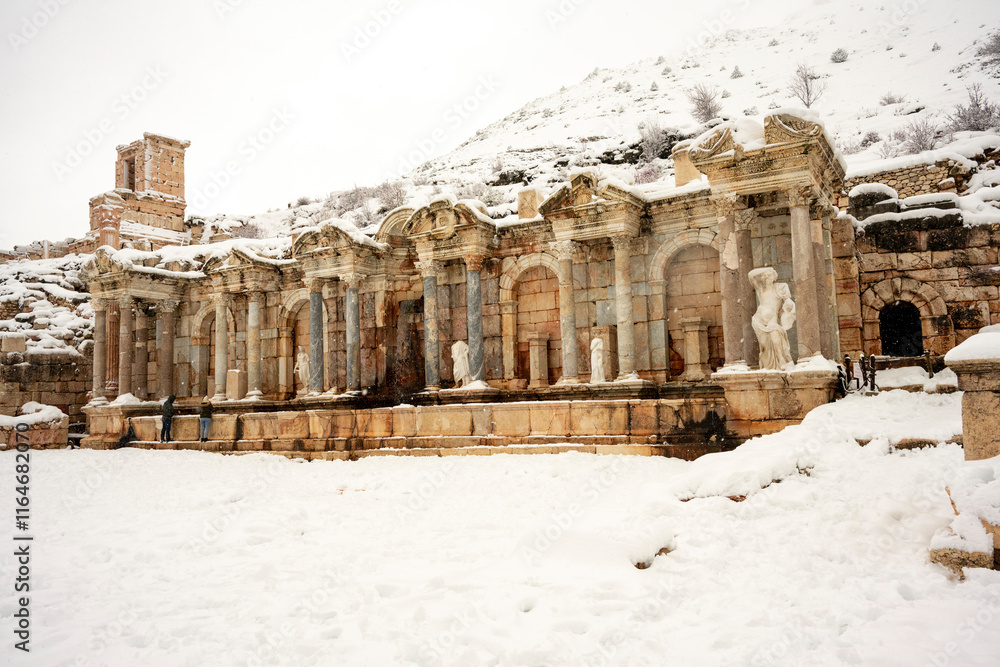 Fototapeta premium o visit the sprawling ruins of Sagalassos, high amid the jagged peaks of Ak Dag, is to approach myth: the ancient ruined city set in stark . Sagalassos Ancient City under the snow on a winter day.