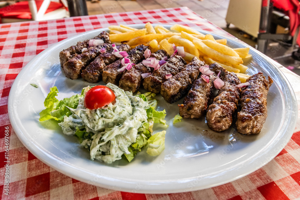 Typical dish of Serbia - cevapi grilled minced meat with french fries and salad