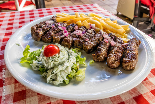Obraz na płótnie Typical dish of Serbia - cevapi grilled minced meat with french fries and salad w salonie