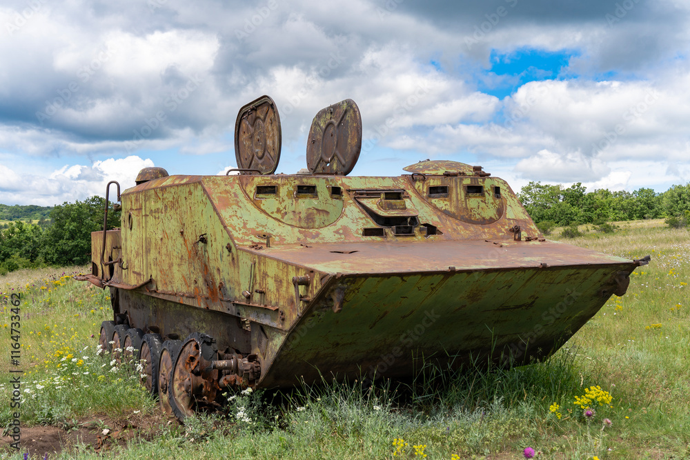 Fototapeta premium Rusty old soviet military vehicle wreck in a field