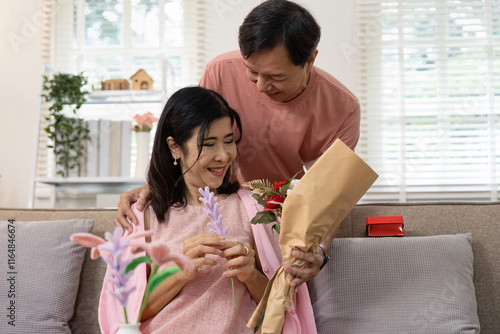 Elderly Couple Celebrating Valentine's Day with Flowers and Gifts in Cozy Home Setting photo