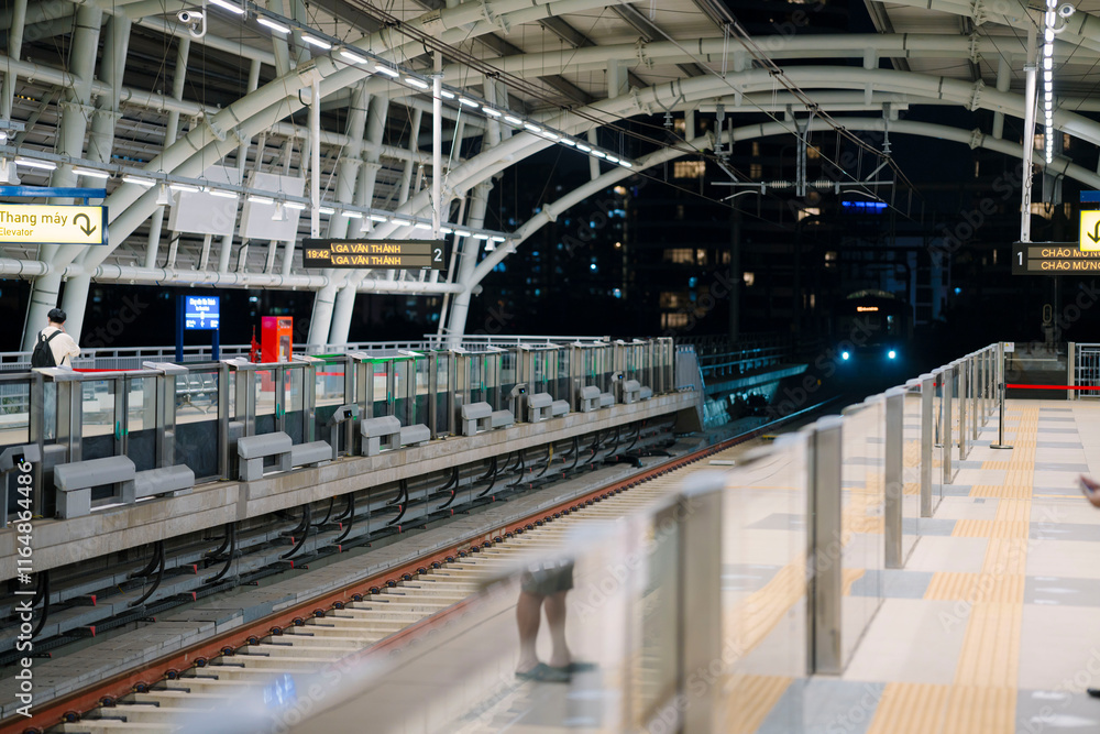 a modern metro train at a station in Ho Chi Minh City, Vietnam. The train features a sleek design with blue stripes, a clean platform, and glass barrier a modern metro train at a station in Ho Chi Minh City, Vietnam. The train features a sleek design with blue stripes, a clean platform, and glass barrier