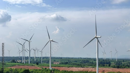 Wallpaper Mural Scenic view of a wind farm with multiple wind turbines in a lush green landscape, set against a backdrop of mountains and a partly cloudy sky, symbolizing renewable energy and sustainability. Torontodigital.ca