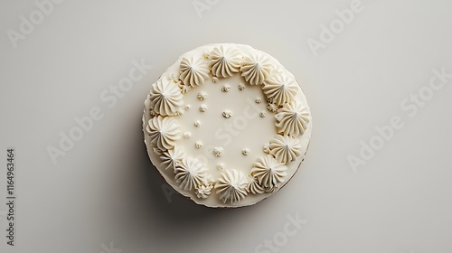 An overhead view of a round birthday cake with minimal decorations displayed on a plain white surface 