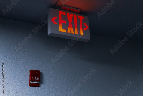 close-up of a large illuminated LED emergency exit sign and fire alarm safety pull installation example