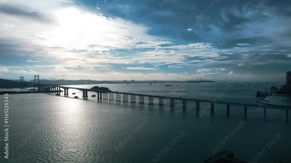 Breathtaking aerial view of a bridge crossing the sea with an island backdrop and dynamic cloudscape Breathtaking aerial view of a bridge crossing the sea with an island backdrop and dynamic cloudscape