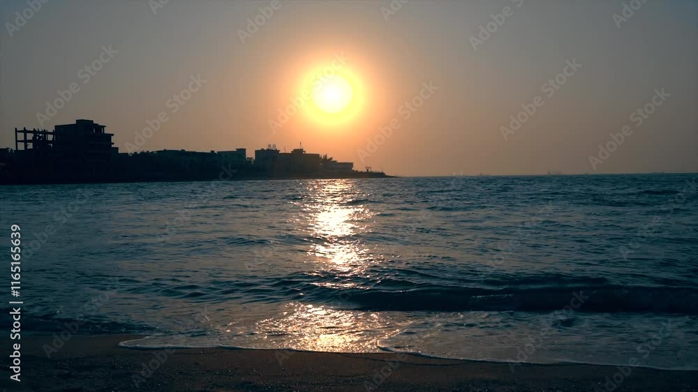Beautiful sunset reflecting on seawater with slow motion effects captured at the shoreline during golden hour