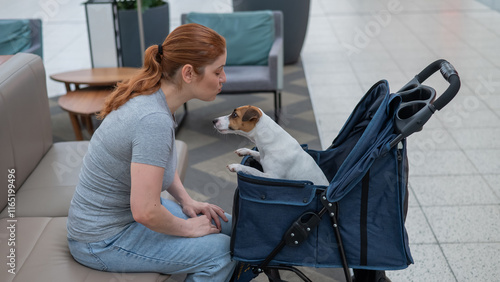 Caucasian woman petting her Jack Russell terrier dog. Shopping with a pet in the mall. photo