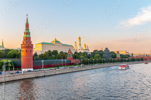 View of Kremlin with Vodovzvodnaya tower, Grand Kremlin Palace from repaired Bolshoy Kamenny Bridge in Moscow city on sunny summer day. Cruise ship sails on the Moscow river photo