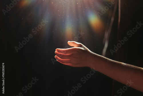 Hand reaching for Sunlight with rainbow flare photo