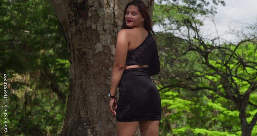 A Latina woman embraces the beauty of a Caribbean park, her dress fluttering in the warm breeze. A Latina woman embraces the beauty of a Caribbean park, her dress fluttering in the warm breeze.