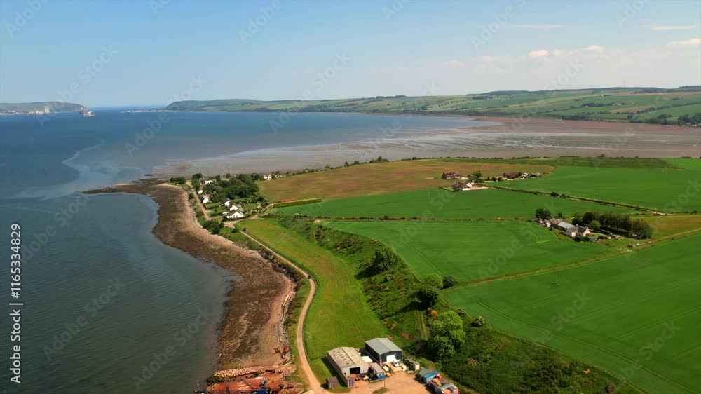 The Cromarty Firth coastline, showcasing green fields, rural houses, a rocky shoreline, and boats at a dock. Captured on a sunny day, this image highlights the beauty of Scotland’s maritime heritage The Cromarty Firth coastline, showcasing green fields, rural houses, a rocky shoreline, and boats at a dock. Captured on a sunny day, this image highlights the beauty of Scotland’s maritime heritage