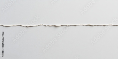 Close-up of torn white paper with jagged edge on light background