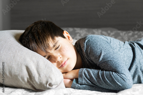 Cute 8 year old Spanish boy napping in bed photo