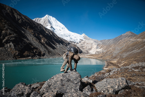 Backpacking woman hiking on high altitude mountain top photo