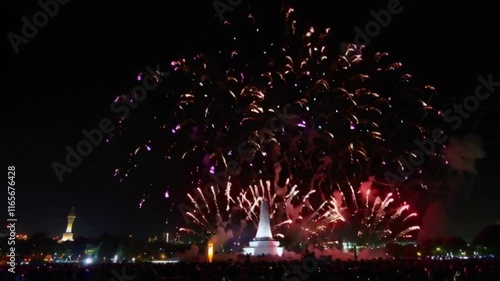 The lively atmosphere of a fireworks party in a city, with vibrant colors, people gathered around a monument. photo