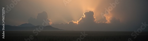 Sunset over field with glowing clouds and mountains
