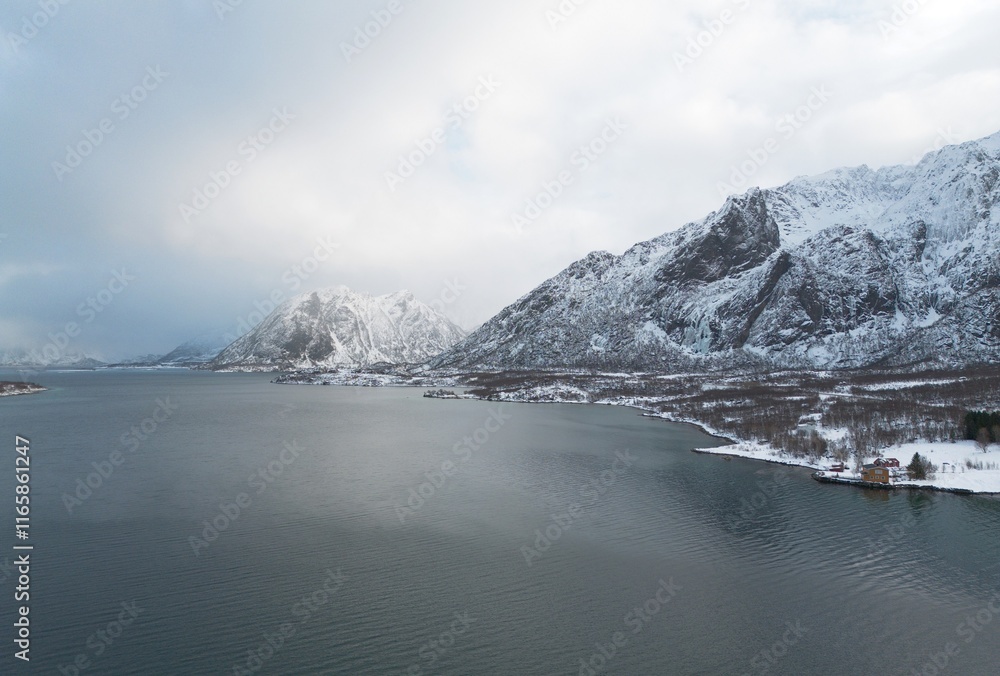Obraz premium Snow capped mountains along a fjord near Holdoya Island, Lofoten, Norway