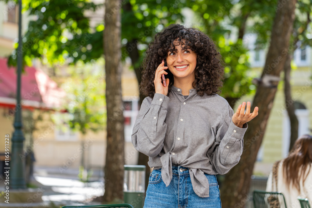 Happy Caucasian young woman having remote conversation communicate speaking by smartphone outdoors. Lady girl talking on phone unexpected good news gossip on city street. Town lifestyles. Sunny park Happy Caucasian young woman having remote conversation communicate speaking by smartphone outdoors. Lady girl talking on phone unexpected good news gossip on city street. Town lifestyles. Sunny park