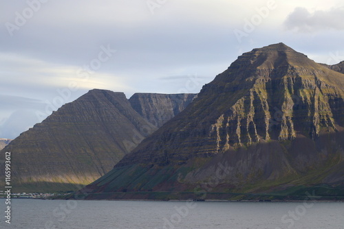 côte nord de l'Islande, falaise et plateau enneigé avec villages colorés photo