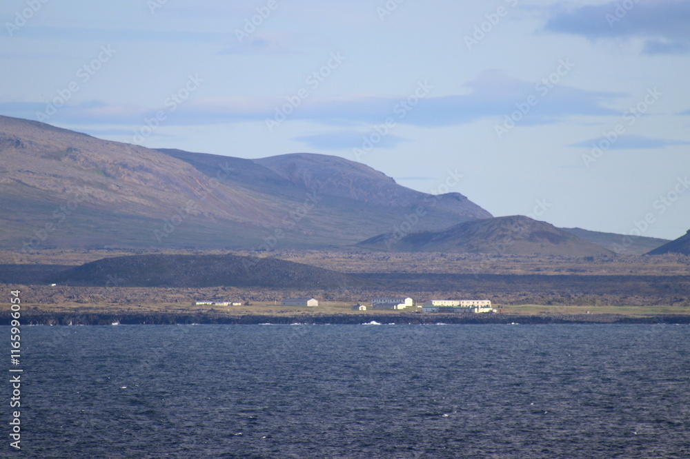 côte nord de l'Islande, falaise et plateau enneigé avec villages colorés côte nord de l'Islande, falaise et plateau enneigé avec villages colorés