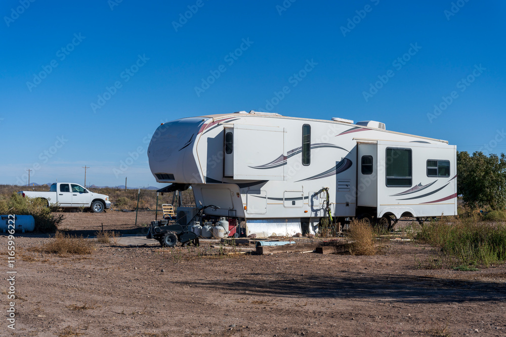 A recreationnal vehicle in a field surrounded by garbage A recreationnal vehicle in a field surrounded by garbage