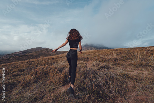 Photos Young woman running away in the mountains in cloudy weather