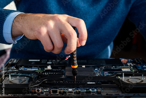 Technician performs disassembly, cleaning and repair of laptop PC. Technical assistance and replacement of CPU, RAM, SSD and application of thermal paste photo