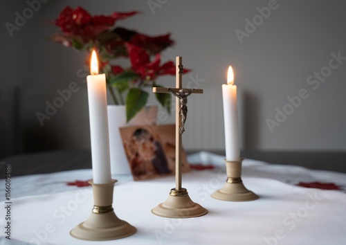 Obraz na płótnie cross with Jesus crucified and two lit candles on a white tablecloth with a Christmas tree in the background w salonie