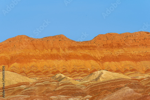 Under the clear sky, the colorful Danxia landforms