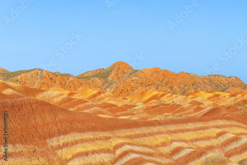 Under the clear sky, the colorful Danxia landforms