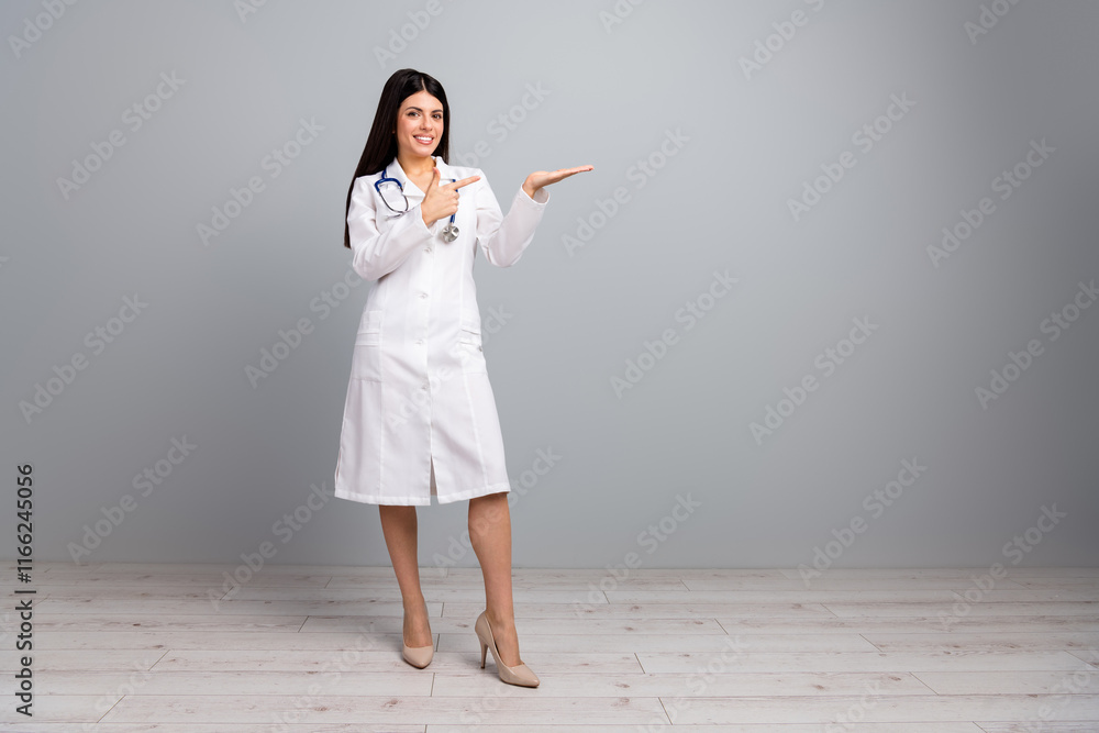 Female doctor in white uniform pointing to copy space with a cheerful expression Female doctor in white uniform pointing to copy space with a cheerful expression