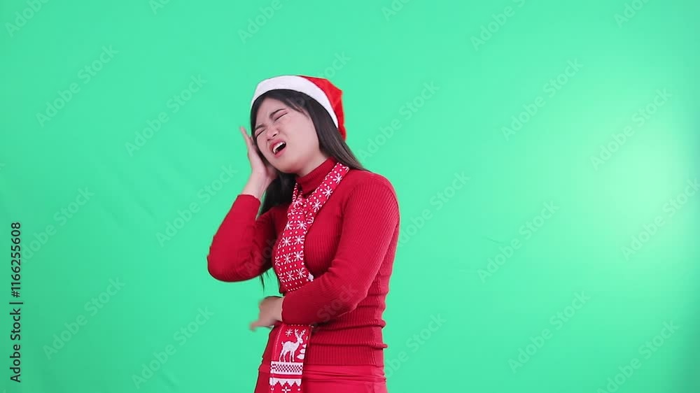 portrait of beautiful woman with right side of her head hurting a lot holding the aching head in her arms, wearing a Christmas sweater, Santa hat and scarf, isolated on a green background,green screen portrait of beautiful woman with right side of her head hurting a lot holding the aching head in her arms, wearing a Christmas sweater, Santa hat and scarf, isolated on a green background,green screen