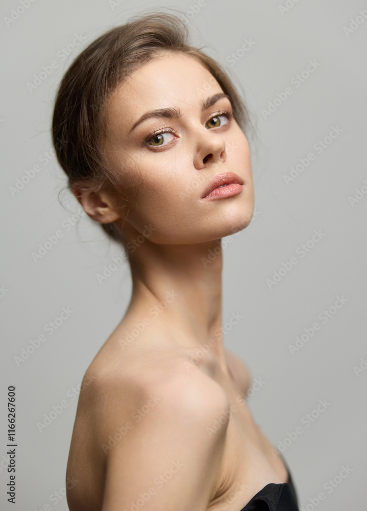 Elegant young woman posing with a serene expression, showcasing natural beauty and minimal makeup. Soft lighting highlights her features against a neutral background. Elegant young woman posing with a serene expression, showcasing natural beauty and minimal makeup. Soft lighting highlights her features against a neutral background.
