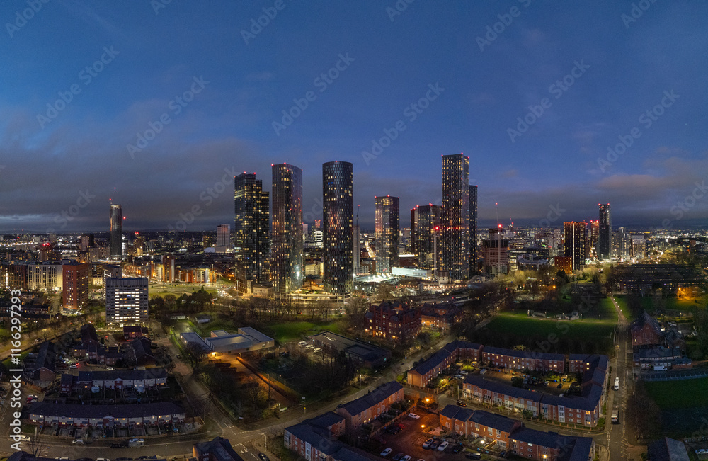 Obraz premium The full nightscape of Manchester reveals a vibrant glow from city lights, illustrating the energetic pulse of urban life in this beautiful metropolis.