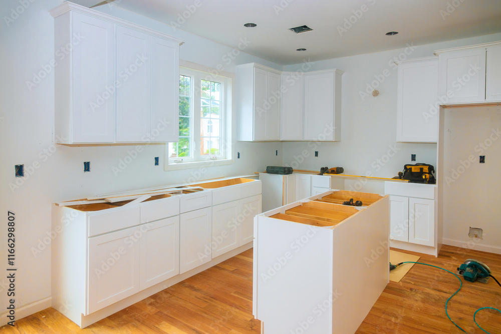 Fototapeta premium Cabinets are being installed in spacious kitchen filled with natural light during home renovation project