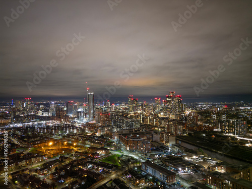 Wallpaper Mural An impressive cityscape during twilight, highlighting the tall, modern buildings adorned with lights, creating a dynamic visual interplay between urban life and natural beauty. Torontodigital.ca