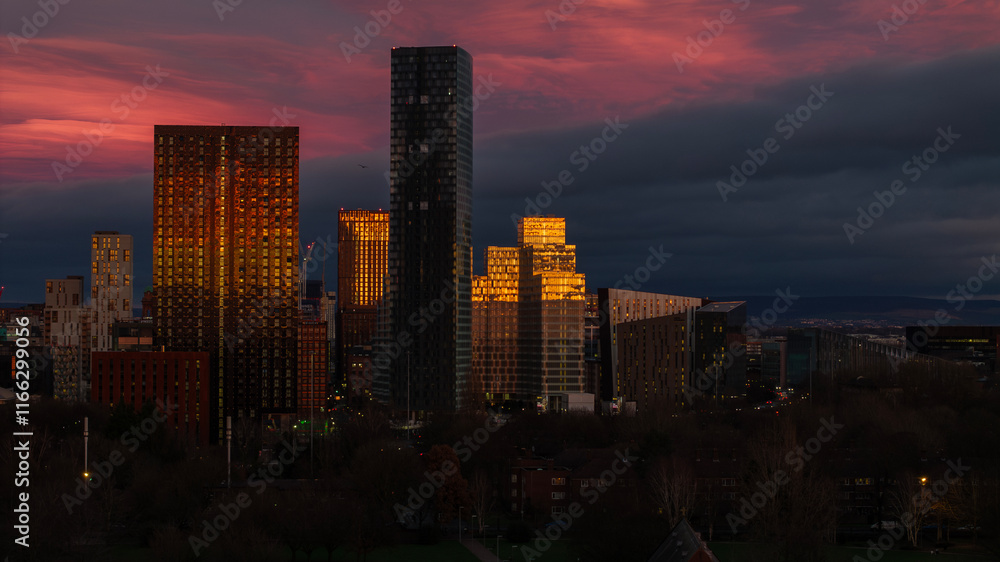 Fototapeta premium Stunning sunset view reflecting off modern buildings, creating a mesmerizing display of light and color that highlights the architectural beauty of the urban landscape.
