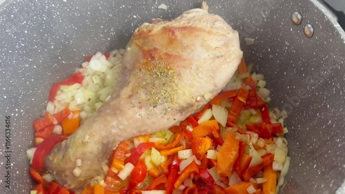 Juicy turkey leg cooking in a saucepan with steaming broth and seasoning.