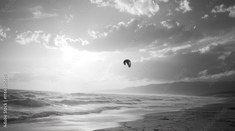 A solitary kitesurfer glides over the waves under a dramatic sky at the beach.